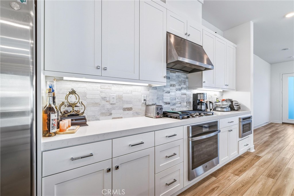 26767 Laurel Mountain Loop Valencia, CA 91381 - Photo 13 of 43 a kitchen with white cabinets and white appliances