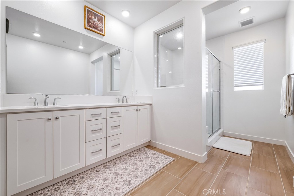 26767 Laurel Mountain Loop Valencia, CA 91381 - Photo 29 of 43 a bathroom with a sink a mirror and a shower