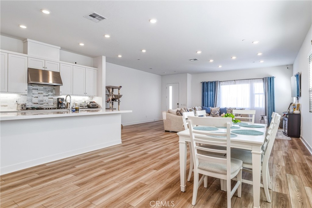 26767 Laurel Mountain Loop Valencia, CA 91381 - Photo 8 of 43 a kitchen with a dining table chairs and wooden floor