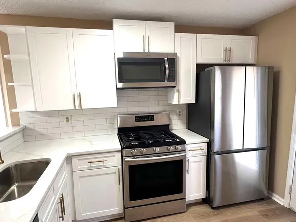 a kitchen with a refrigerator sink and stove top oven
