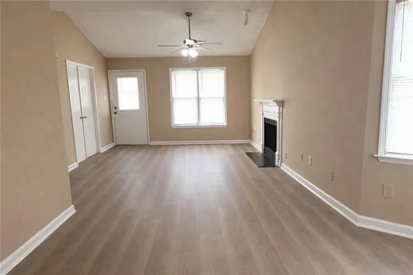 an empty room with wooden floor and windows