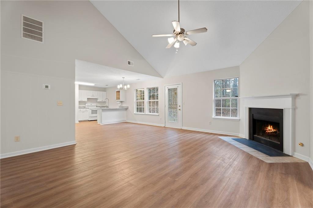 7815 Ridge Top Terrace Douglasville, GA 30134 - Photo 14 of 31 a view of an empty room with wooden floor fireplace and a window