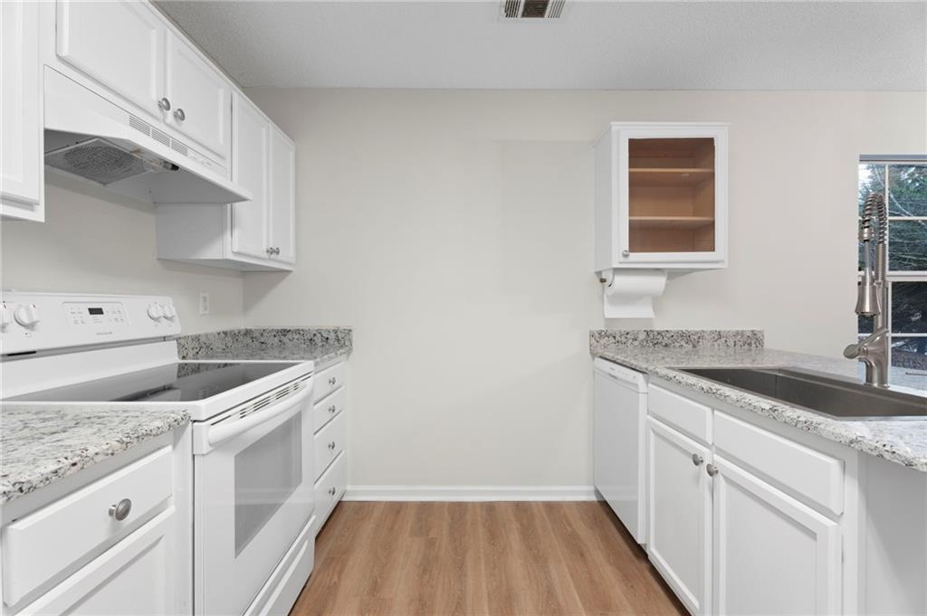 7815 Ridge Top Terrace Douglasville, GA 30134 - Photo 18 of 31 a kitchen with granite countertop white cabinets and white appliances