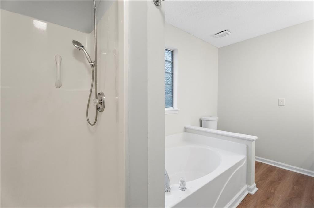 7815 Ridge Top Terrace Douglasville, GA 30134 - Photo 10 of 31 a bathroom with a white bath tub and a shower