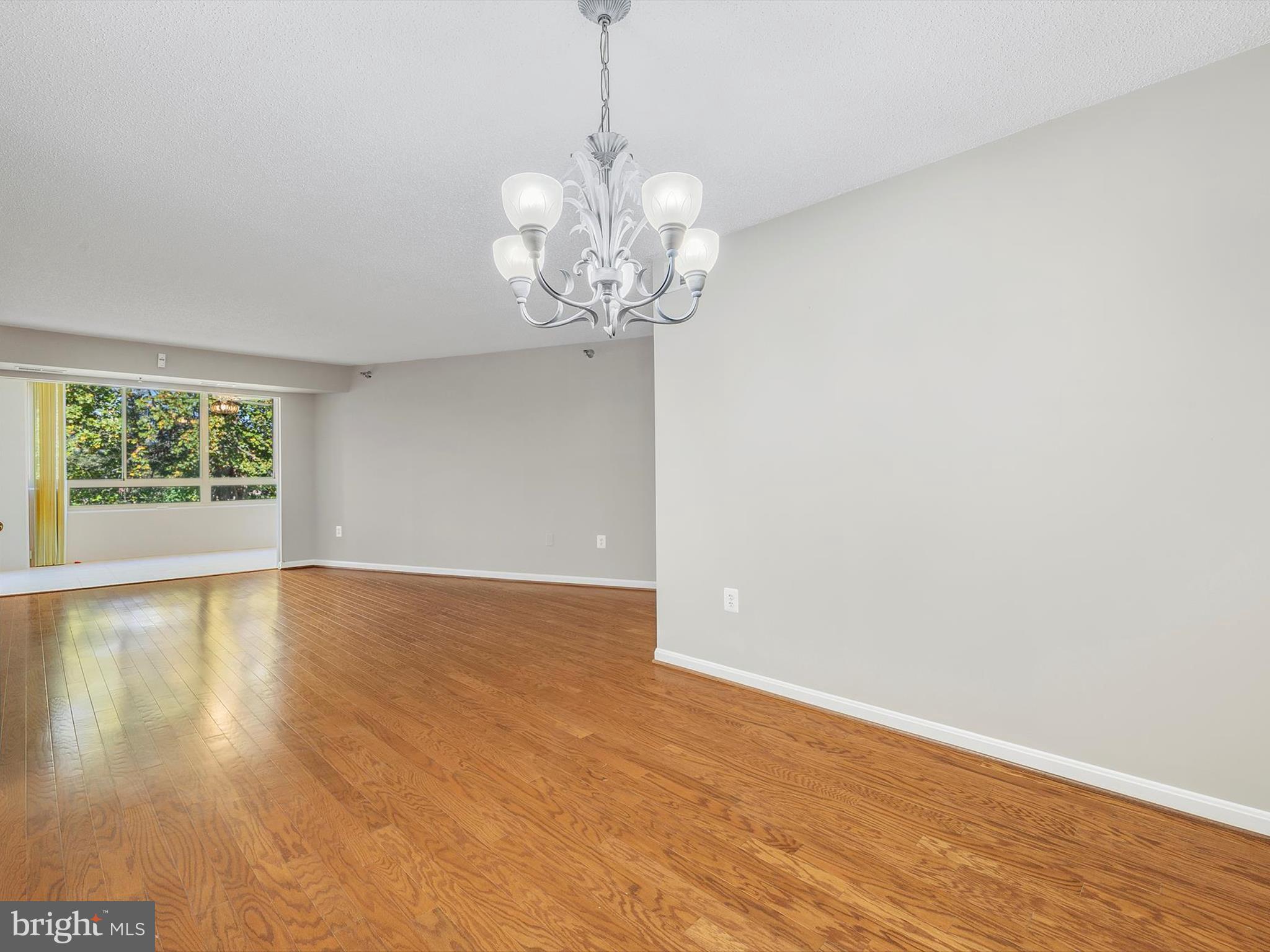14809 Pennfield Circle, Unit 406 Silver Spring, MD 20906 - Photo 14 of 45 a view of an empty room with wooden floor and a window