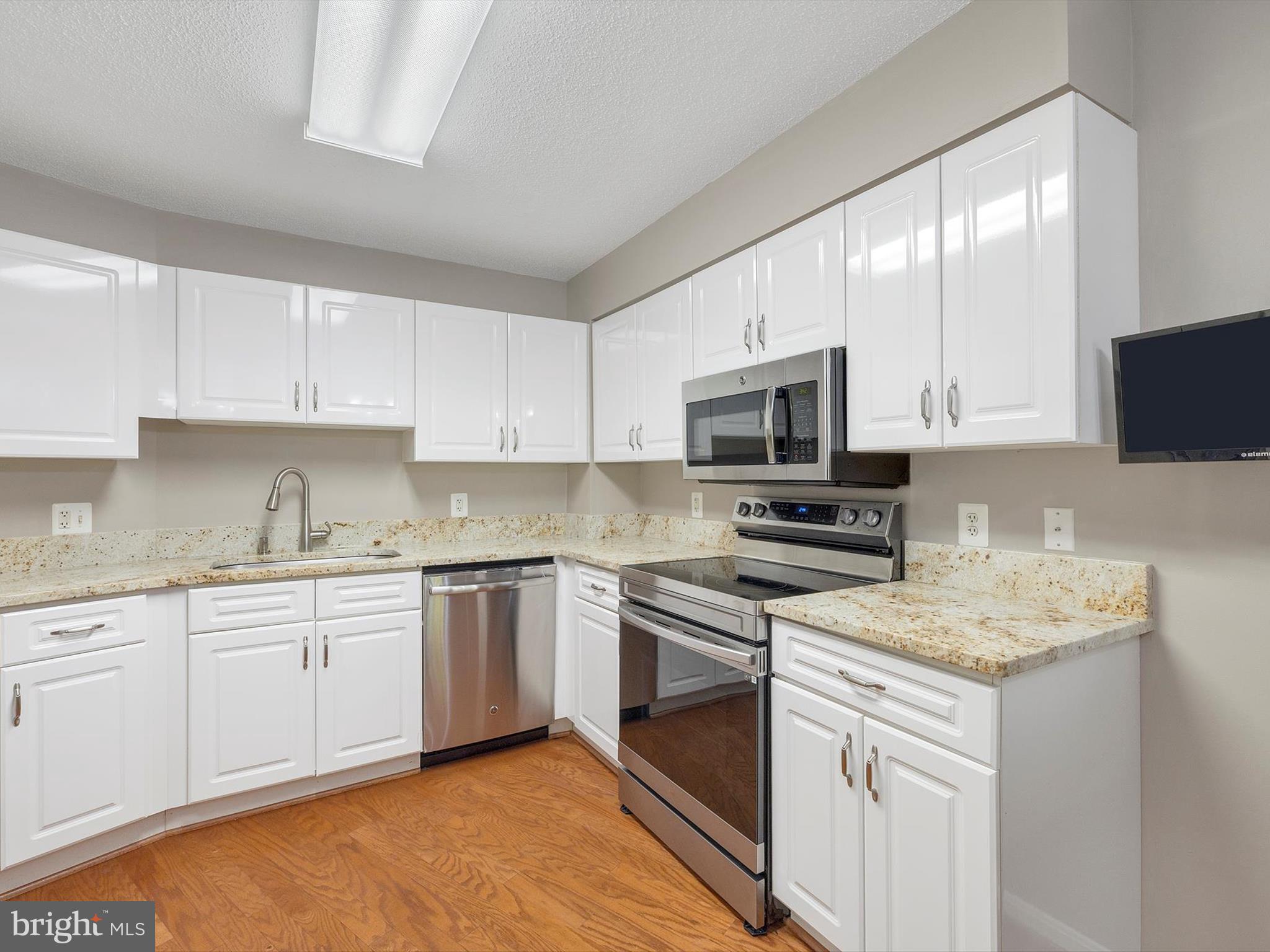 14809 Pennfield Circle, Unit 406 Silver Spring, MD 20906 - Photo 16 of 45 a kitchen with sink a microwave a stove and cabinets