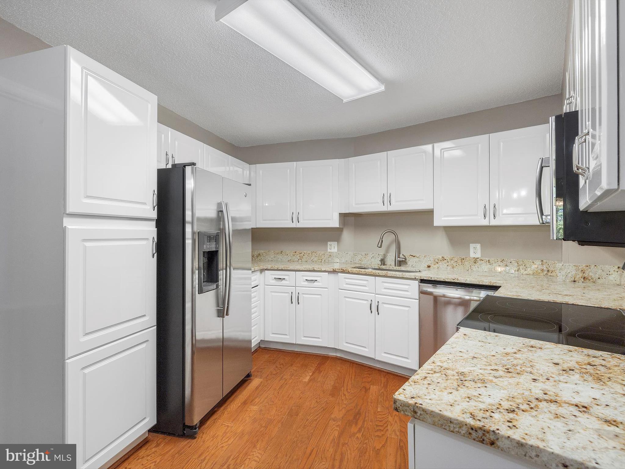 14809 Pennfield Circle, Unit 406 Silver Spring, MD 20906 - Photo 17 of 45 a kitchen with granite countertop stainless steel appliances refrigerator sink and cabinets