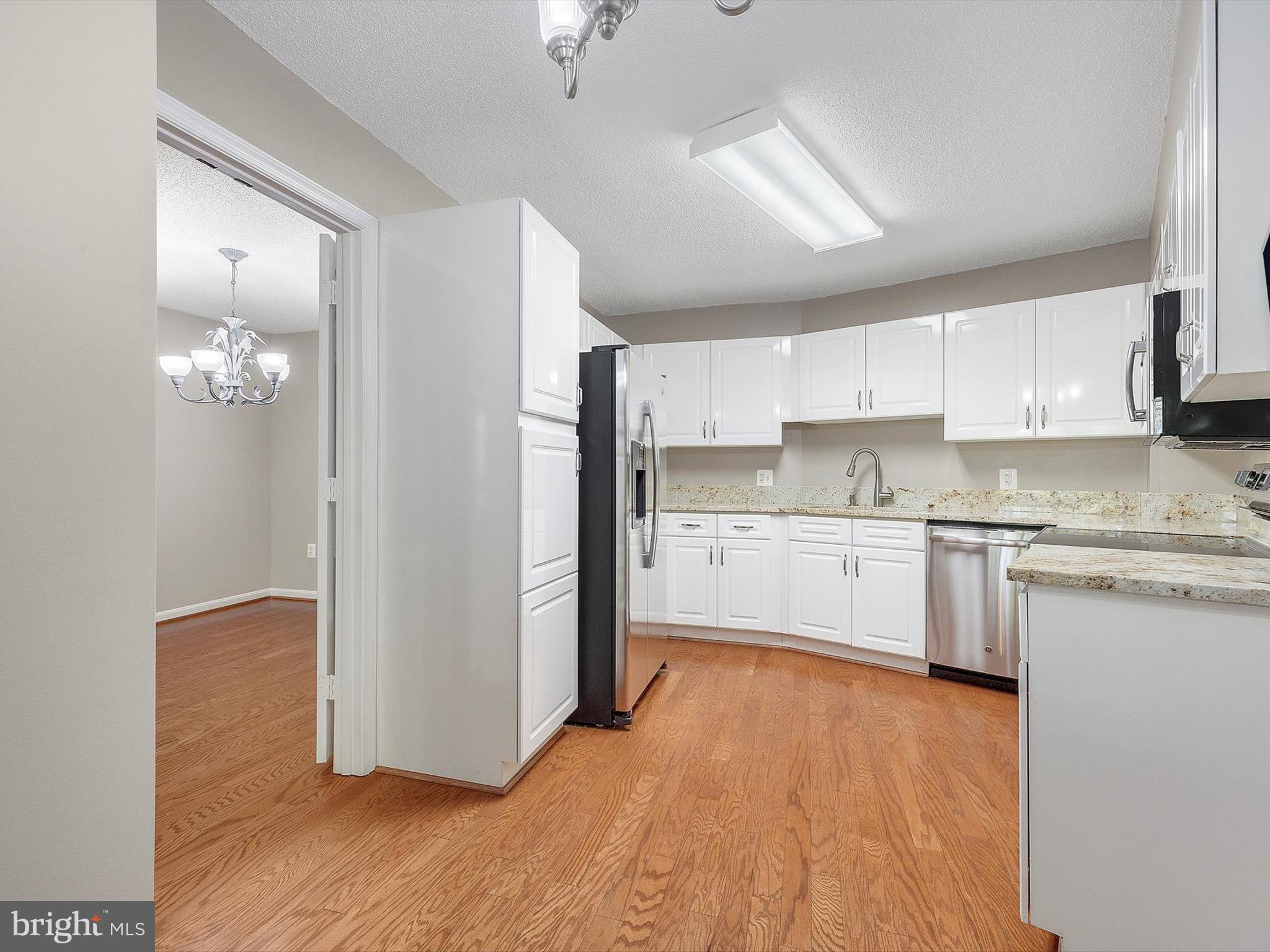 14809 Pennfield Circle, Unit 406 Silver Spring, MD 20906 - Photo 22 of 45 a kitchen with stainless steel appliances granite countertop a refrigerator sink and cabinets