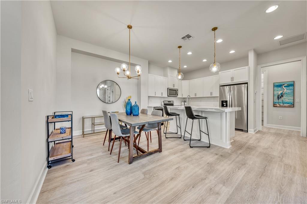6421 Carnival Road Naples, FL 34113 - Photo 12 of 28 a view of a kitchen with dining table and chairs