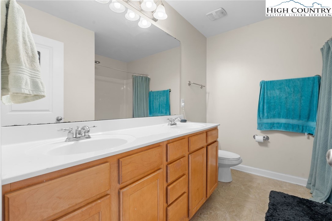 166 Azor Court, Unit 2A Boone, NC 28607 - Photo 17 of 38 a bathroom with a double vanity sink toilet and shower