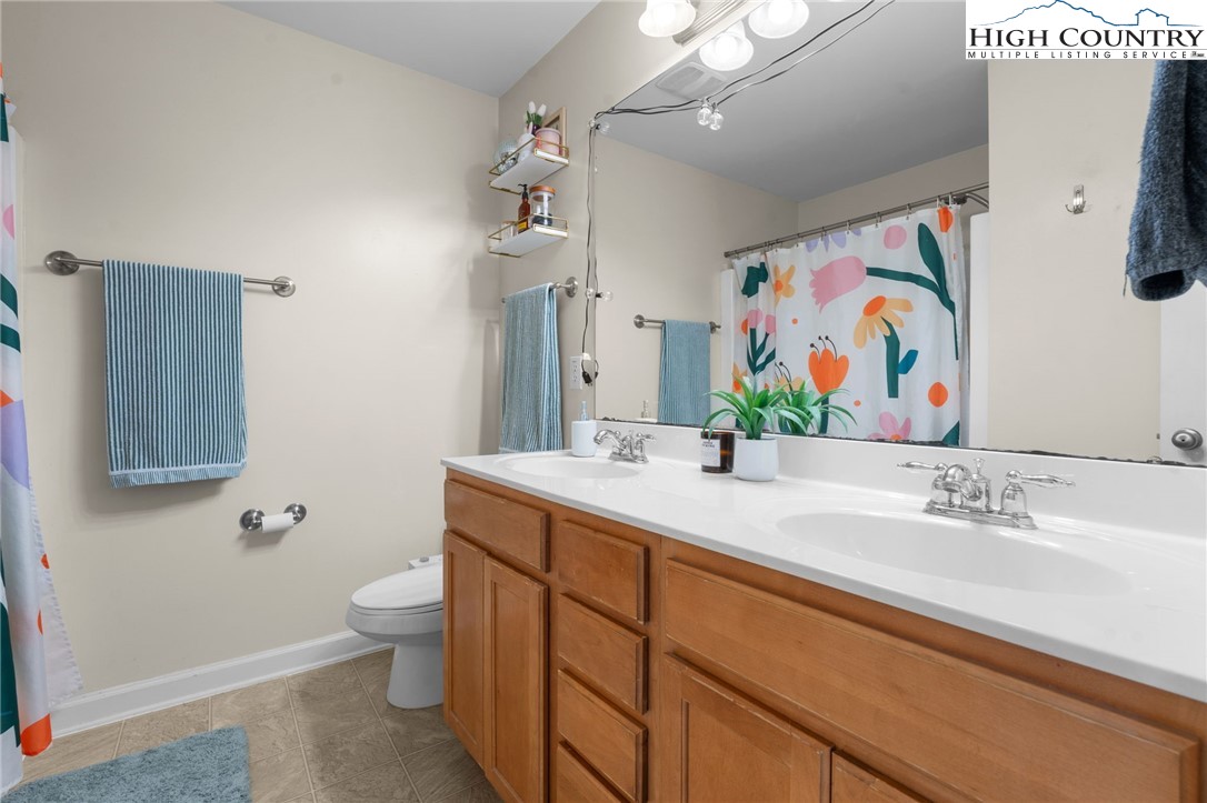 166 Azor Court, Unit 2A Boone, NC 28607 - Photo 22 of 38 a bathroom with a granite countertop sink mirror vanity and toilet