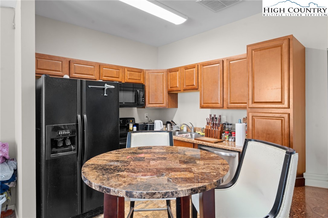 166 Azor Court, Unit 2A Boone, NC 28607 - Photo 29 of 38 a kitchen with stainless steel appliances granite countertop a refrigerator a sink a stove and chairs