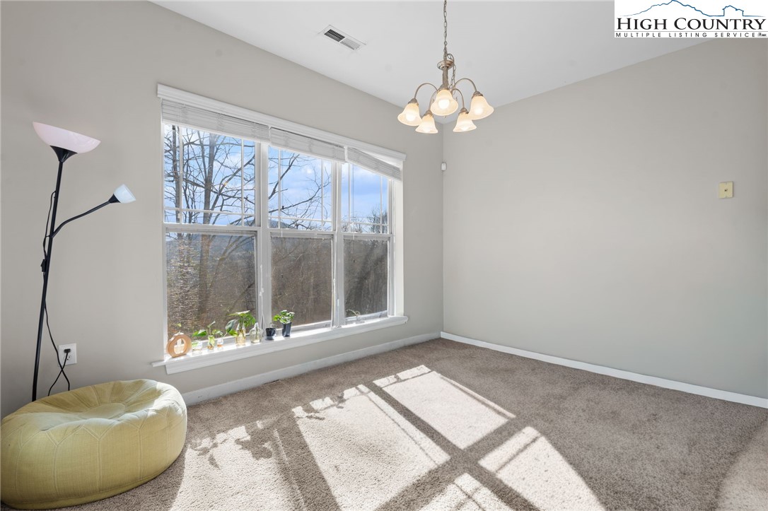 166 Azor Court, Unit 2A Boone, NC 28607 - Photo 9 of 38 a bedroom with a bed and a chandelier