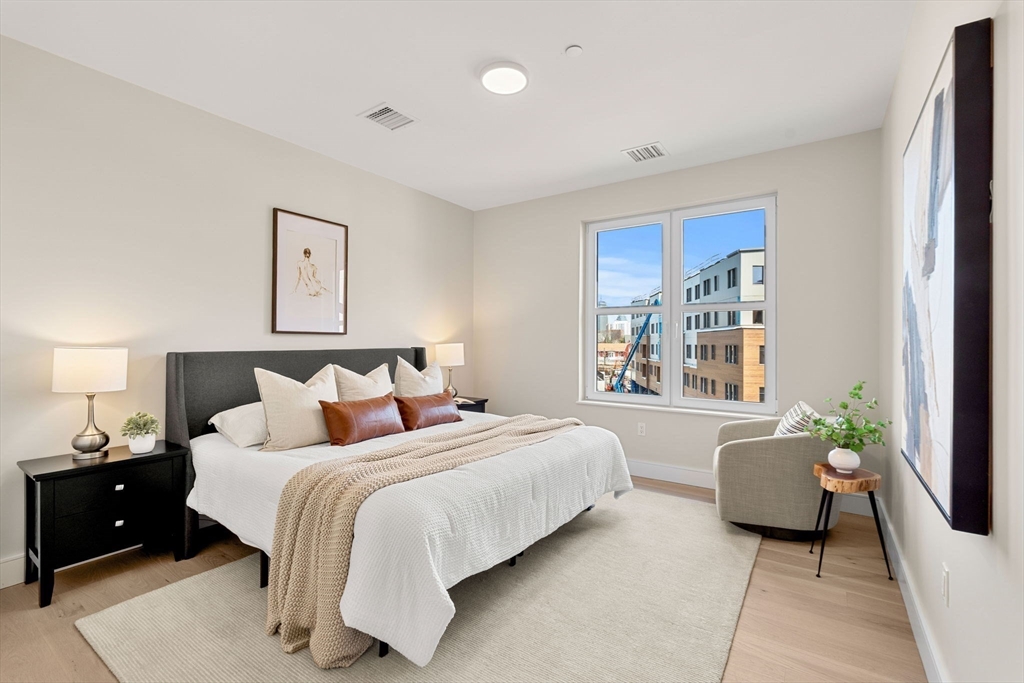 27 Guild Street, Unit 301 Boston, MA 02119 - Photo 13 of 29 a bedroom with a bed and a couch