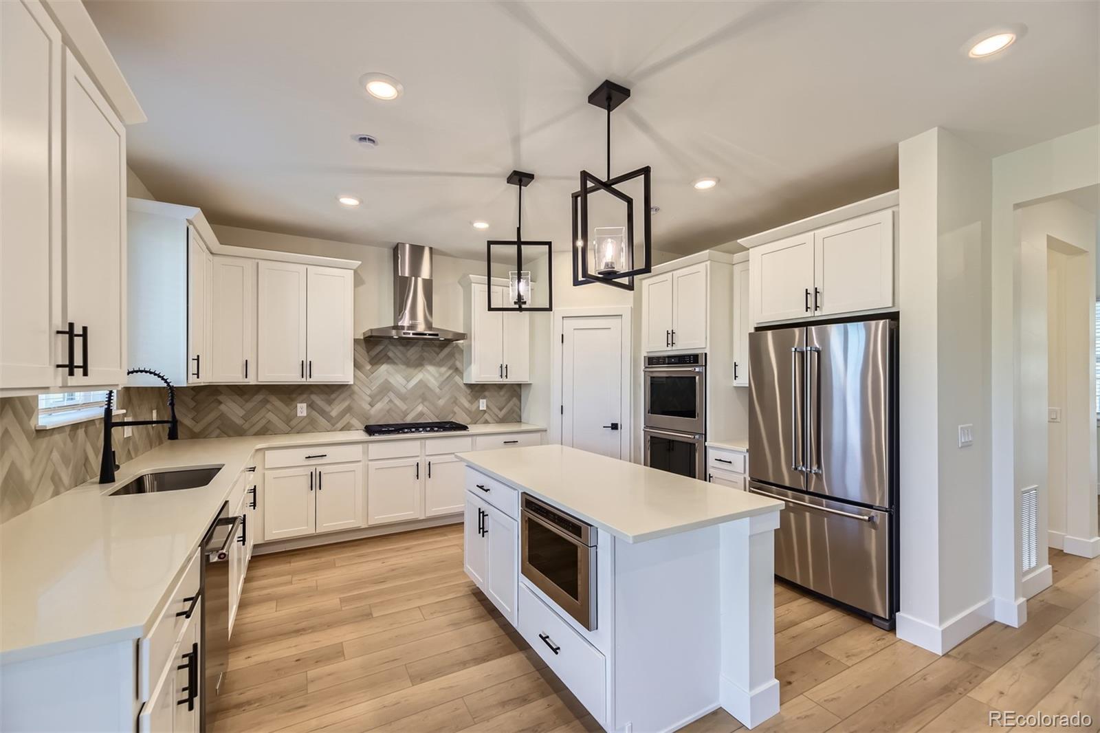 42972 Colonial Trail Elizabeth, CO 80107 - Photo 5 of 27 a kitchen with stainless steel appliances granite countertop a refrigerator a sink dishwasher a stove and white cabinets with wooden floor