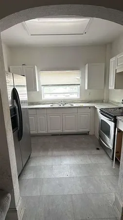 a kitchen with granite countertop a sink and a stove top oven