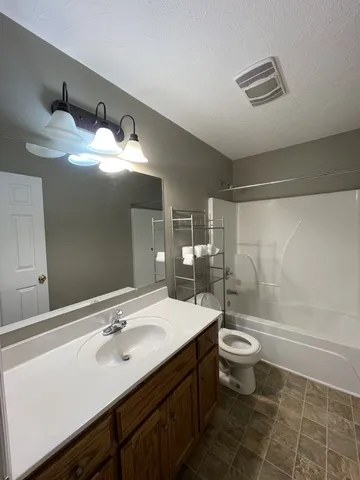 a bathroom with a double vanity sink toilet and a mirror