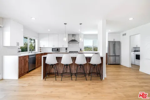 a large kitchen with a table and chairs
