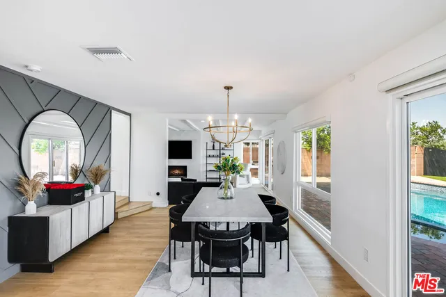 a view of a dining room with furniture a chandelier and wooden floor