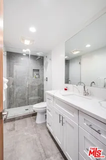 a bathroom with a double vanity sink toilet and shower