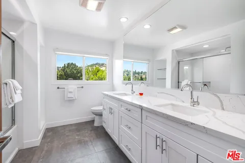 a spacious bathroom with a double vanity sink a mirror and a bathtub