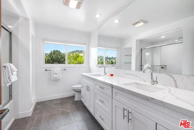 a spacious bathroom with a double vanity sink a mirror and a bathtub