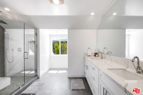 a spacious bathroom with double vanity and a shower