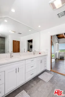 a spacious bathroom with a granite countertop sink and a mirror
