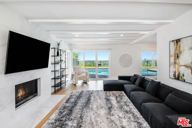 a living room with furniture a flat screen tv and a fireplace