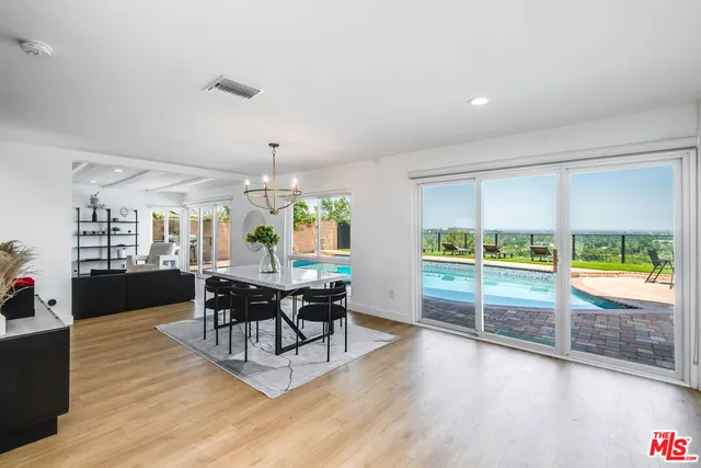 a living room with furniture a dining table and a large window