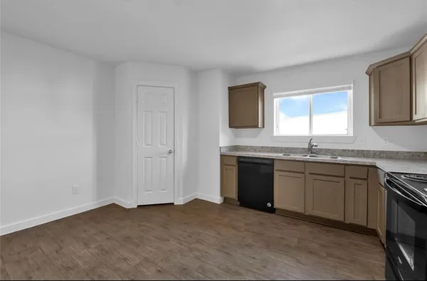 a kitchen with granite countertop a sink cabinets and stainless steel appliances