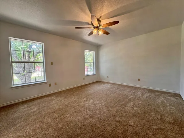 an empty room with a window and a fan