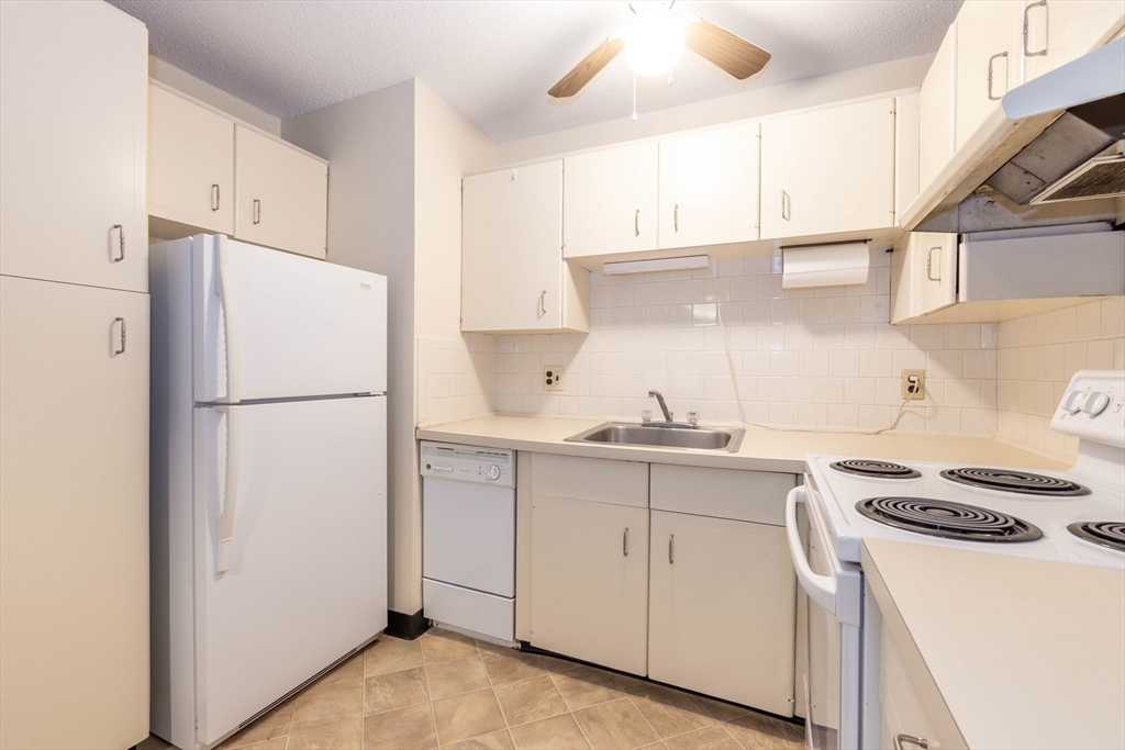 71 Nicholas Road, Unit H Framingham, MA 01701 - Photo 4 of 29 a kitchen with a sink a refrigerator and cabinets