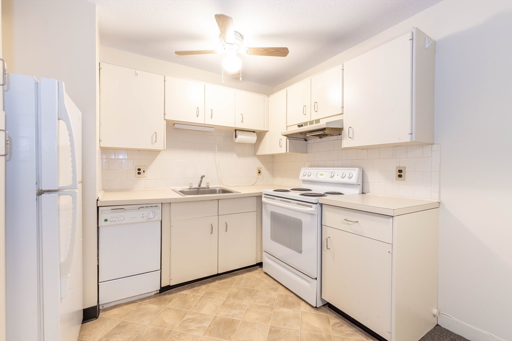 71 Nicholas Road, Unit H Framingham, MA 01701 - Photo 5 of 29 a kitchen with stainless steel appliances granite countertop white cabinets a sink a stove a refrigerator and a refrigerator