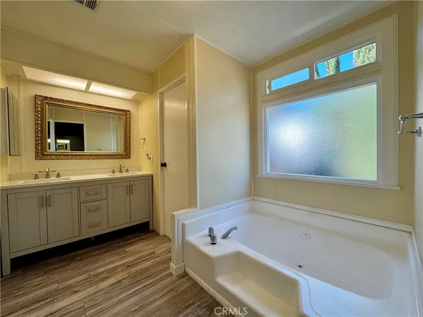 a bathroom with a granite countertop sink mirror and bathtub