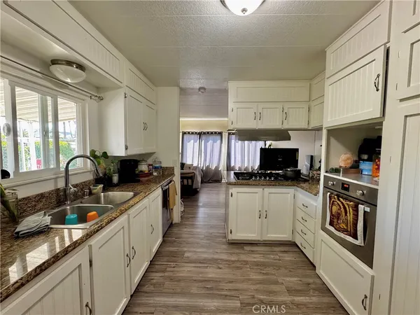 a large kitchen with stainless steel appliances granite countertop a stove refrigerator and a sink