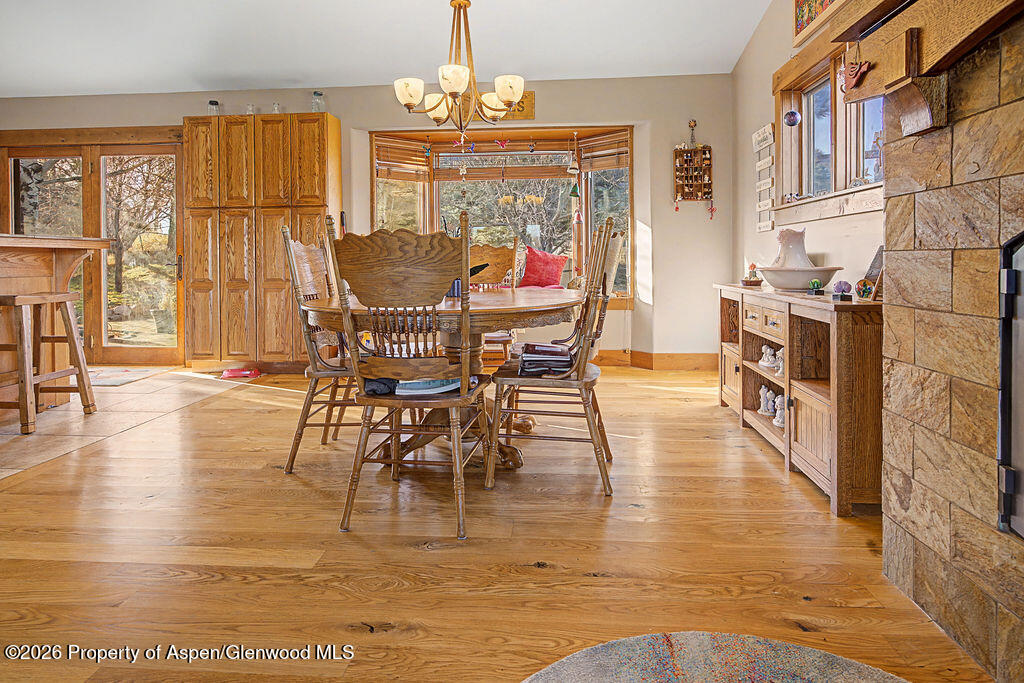 1040 Bryan Way Craig, CO 81625 - Photo 11 of 54 a dining room with wooden floor a chandelier a glass table and chairs