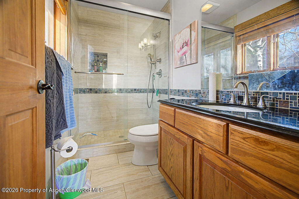 1040 Bryan Way Craig, CO 81625 - Photo 22 of 54 a bathroom with a granite countertop toilet a sink and a shower