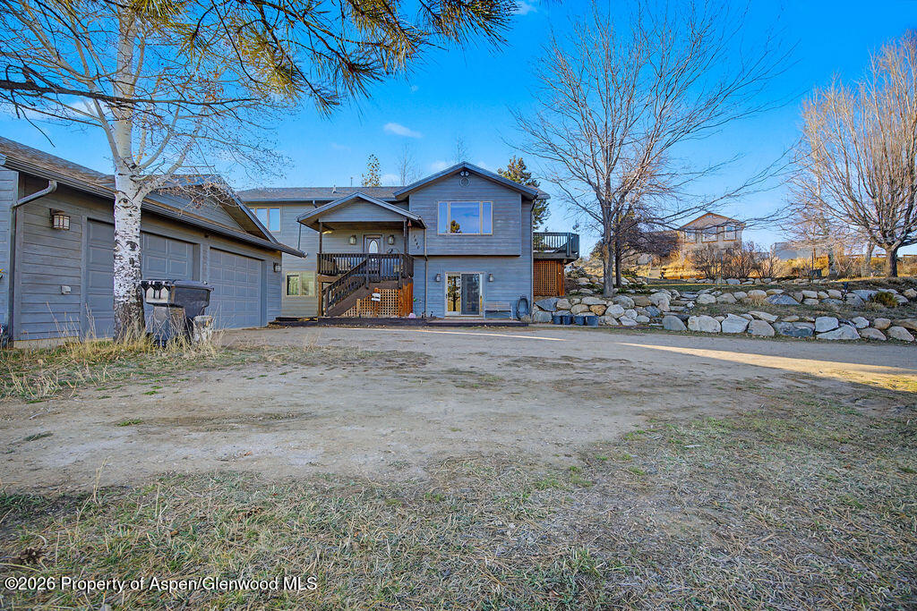 1040 Bryan Way Craig, CO 81625 - Photo 4 of 54 a front view of a house with a dirt yard and a large tree