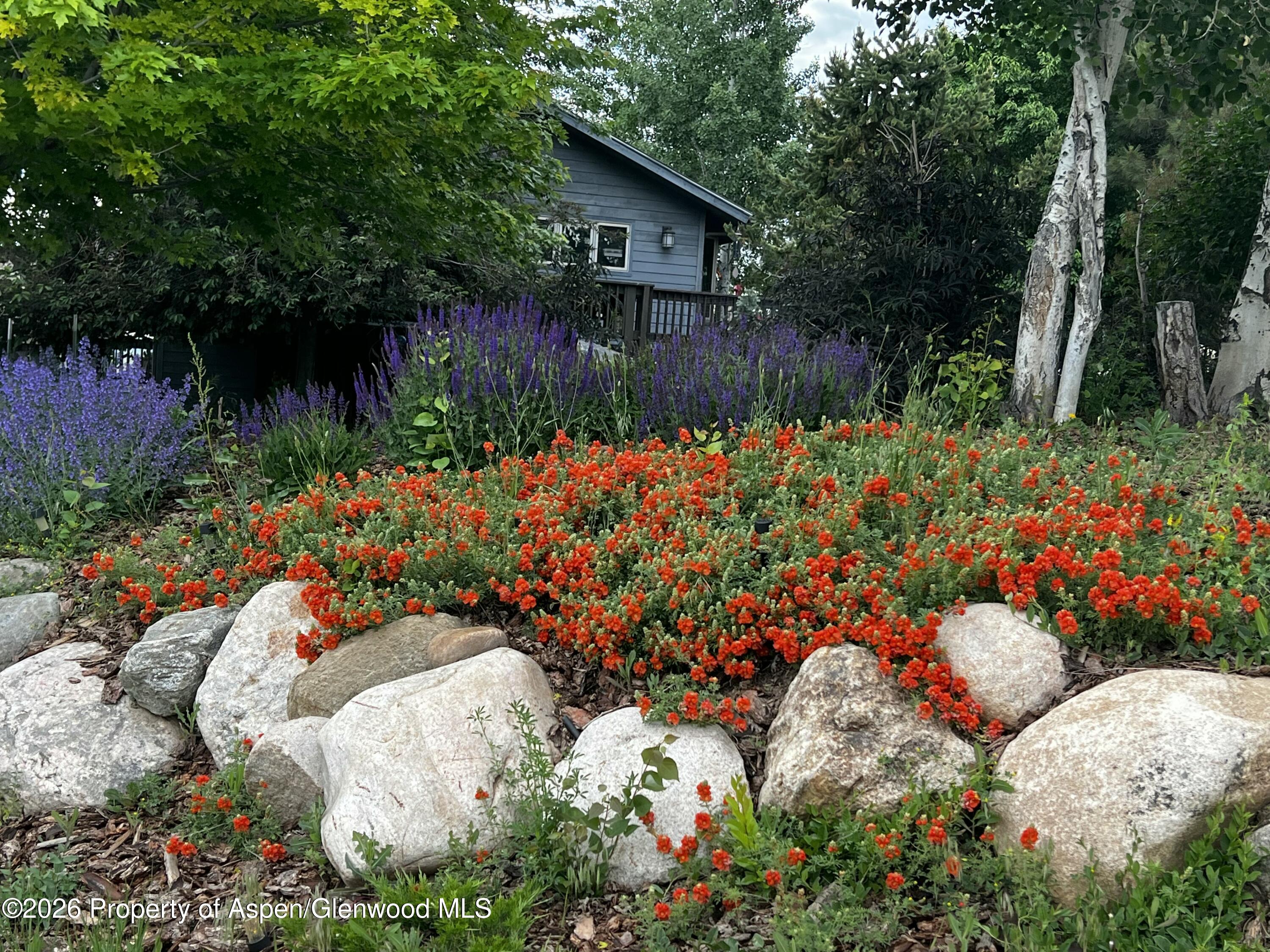 1040 Bryan Way Craig, CO 81625 - Photo 51 of 54 a garden with flowers and wooden fence