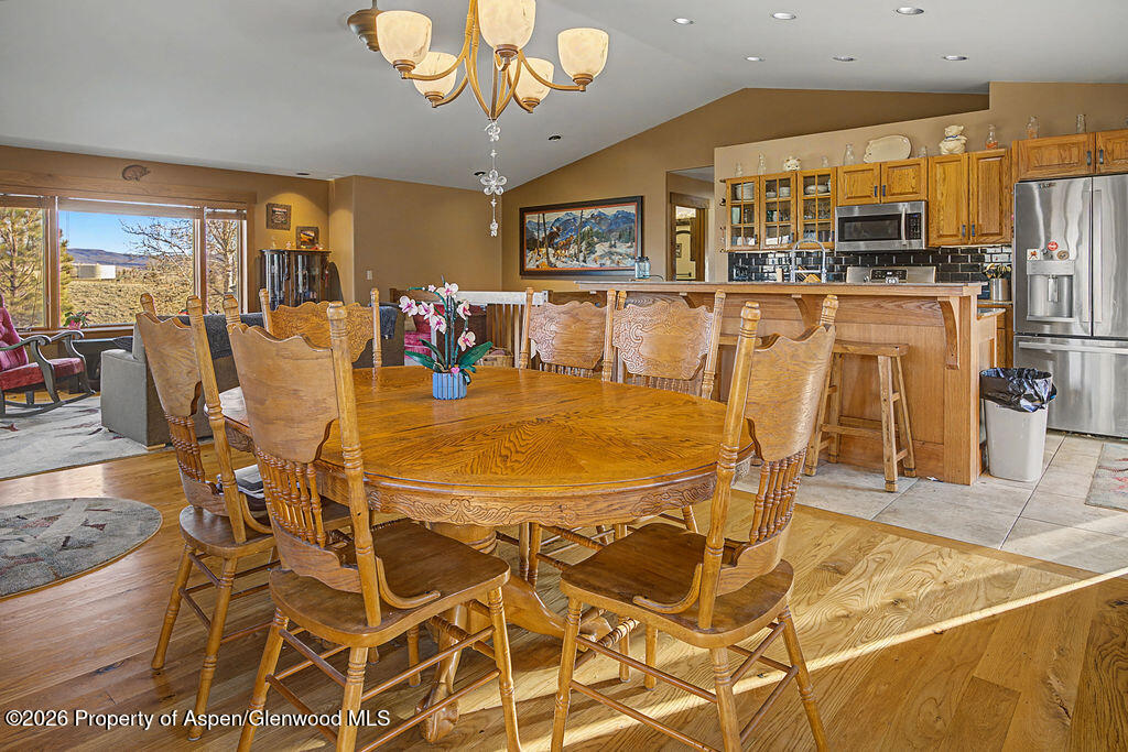 1040 Bryan Way Craig, CO 81625 - Photo 7 of 54 a dining room filled with stainless steel appliances kitchen island granite countertop a table chairs and a refrigerator
