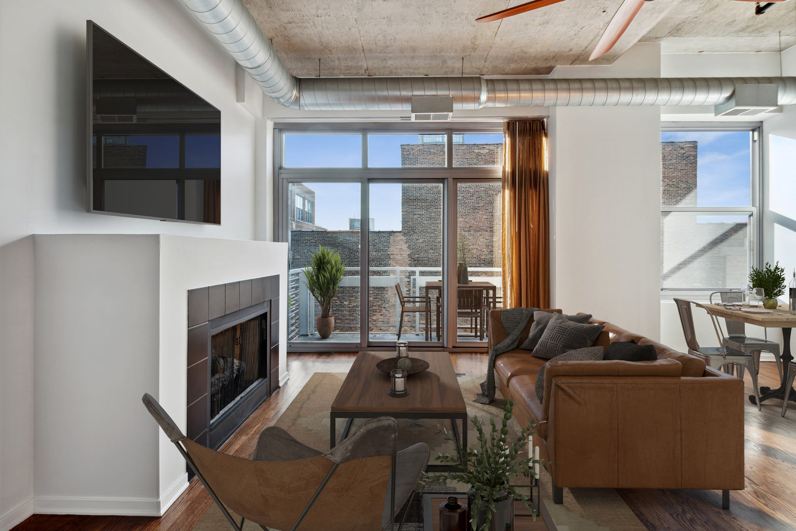 933 West Van Buren Street, Unit 824 Chicago, IL 60607 - Photo 3 of 18 a living room with furniture a flat screen tv and a fireplace