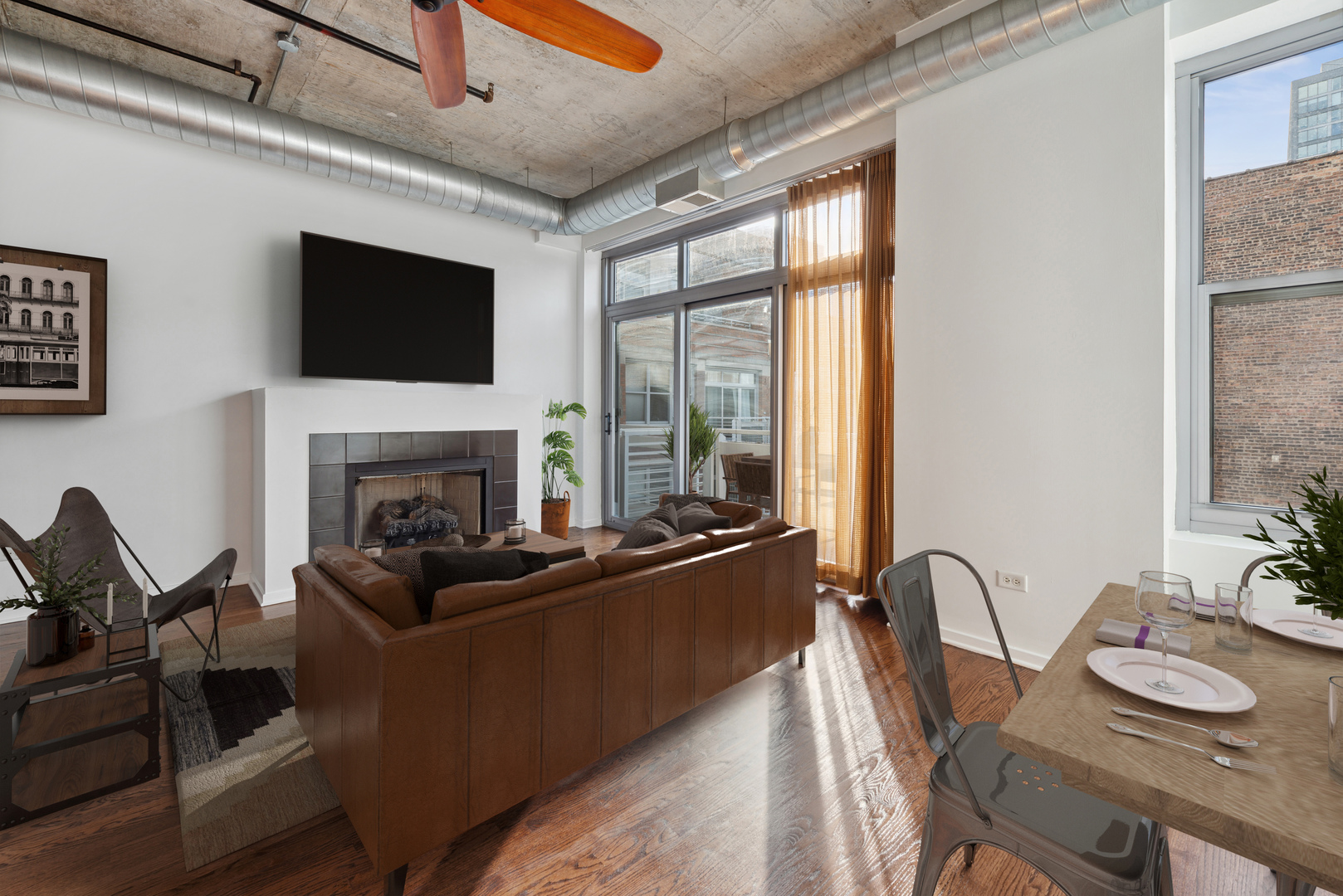 933 West Van Buren Street, Unit 824 Chicago, IL 60607 - Photo 4 of 18 a living room with furniture a fireplace and a flat screen tv