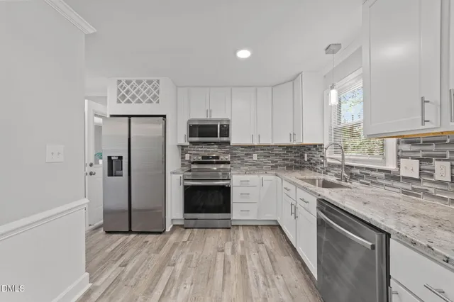 a kitchen with a refrigerator sink and cabinets