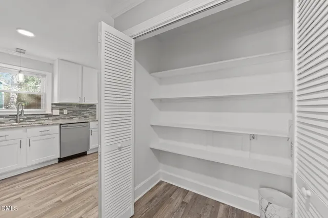 a kitchen with a refrigerator and white cabinets