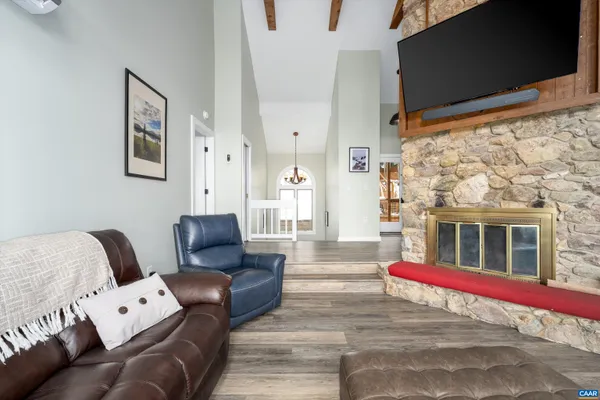 a living room with stainless steel appliances granite countertop a stove and white cabinets with wooden floors