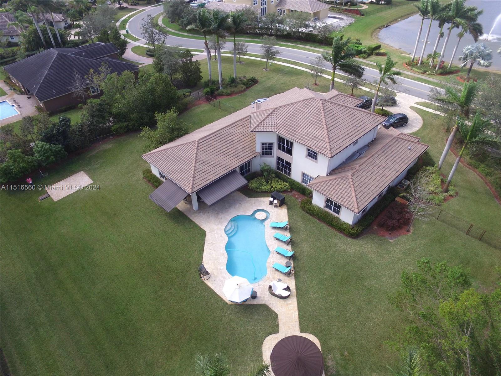 an aerial view of a house with outdoor space pool patio and lake view