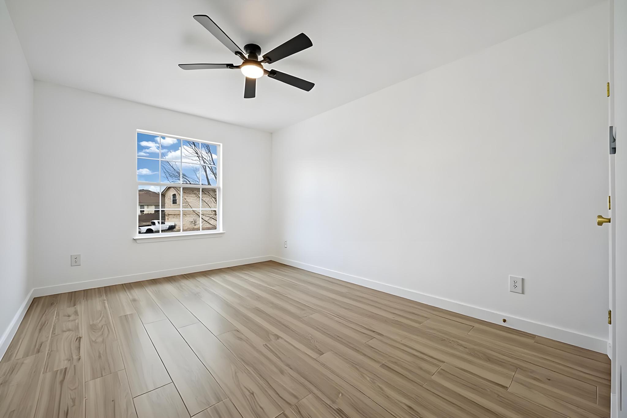 13501 Sierra Wind Lane Elgin, TX 78621 - Photo 10 of 19 Room featuring wood-finish flooring, a white trim baseboard, and a multi-pane window