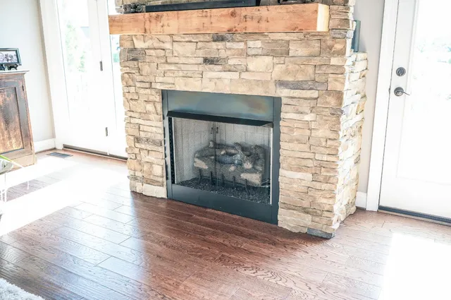 a view of empty room with wooden floor and fireplace