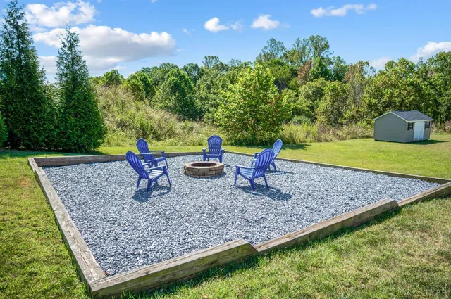 a view of a backyard with barn and large trees